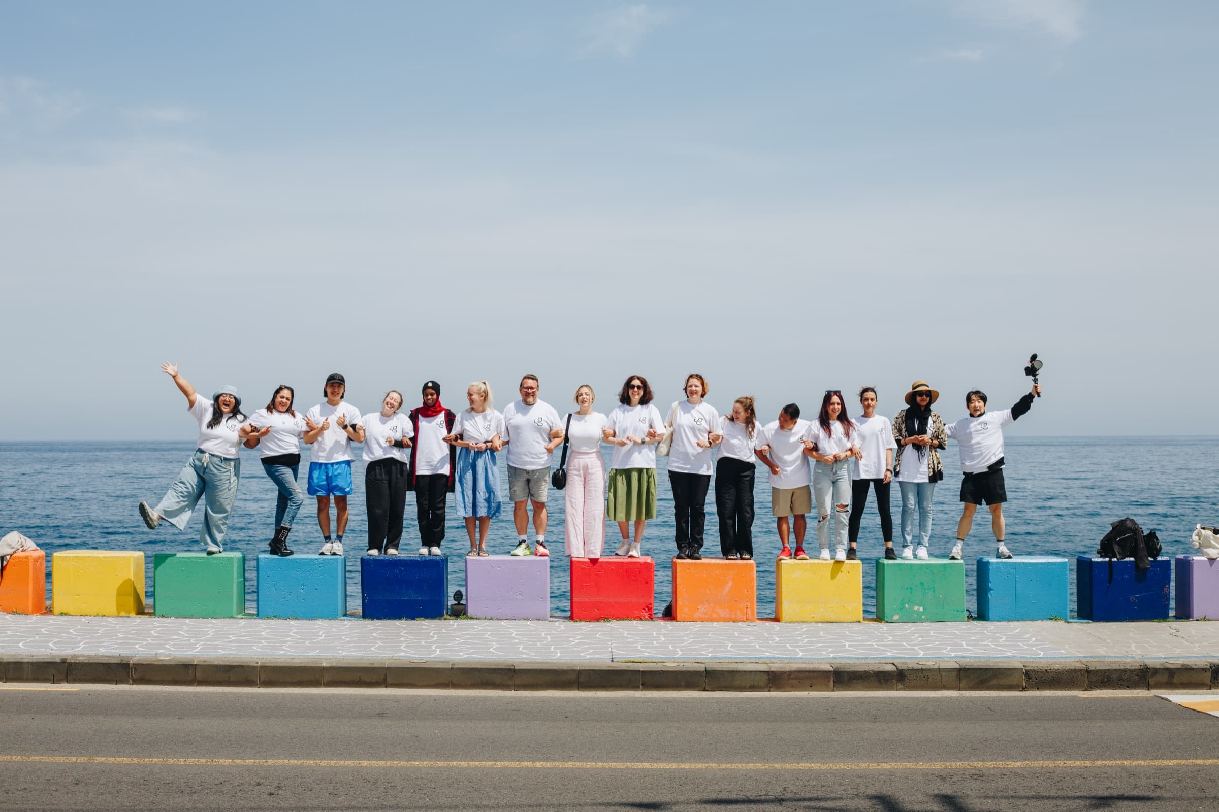 A Goodmate creator group linking arms by the sea in Korea