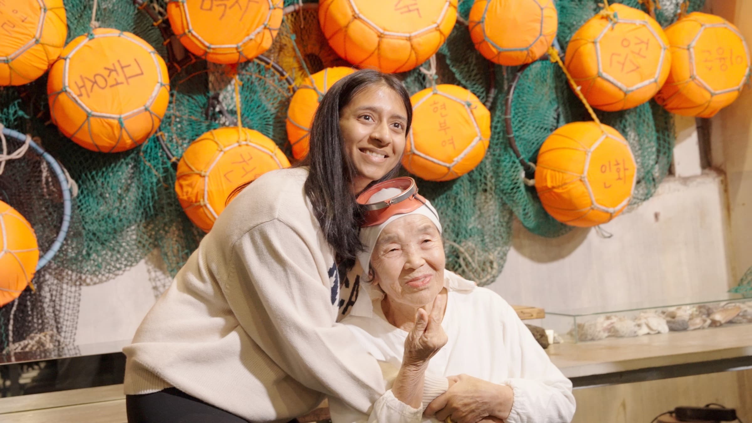 A creator sharing a hug with a Jeju haenyeo grandmother